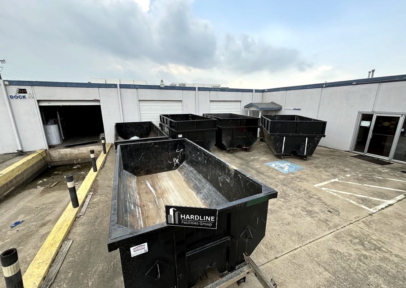 Hardline-branded roll-off dumpsters staged for commercial site cleanup in DFW